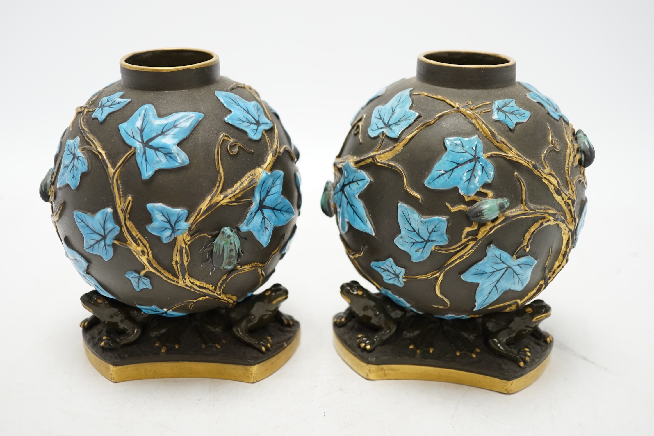 A pair of George Jones Kumassie vases designed by Christopher Dresser, relief moulded designs, frog supports, 14cm. Condition - good